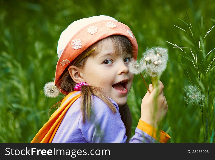 Funny girl with a bouquet of dandelions on background of green grass. Funny girl with a bouquet of dandelions on background of green grass