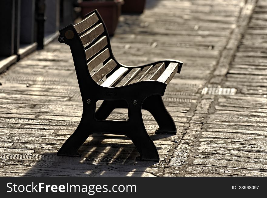 Wooden bench in a sidewalk