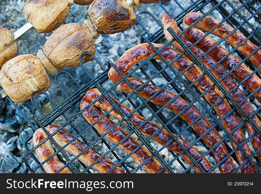 Grilled sausages and potato on barbecue. Grilled sausages and potato on barbecue