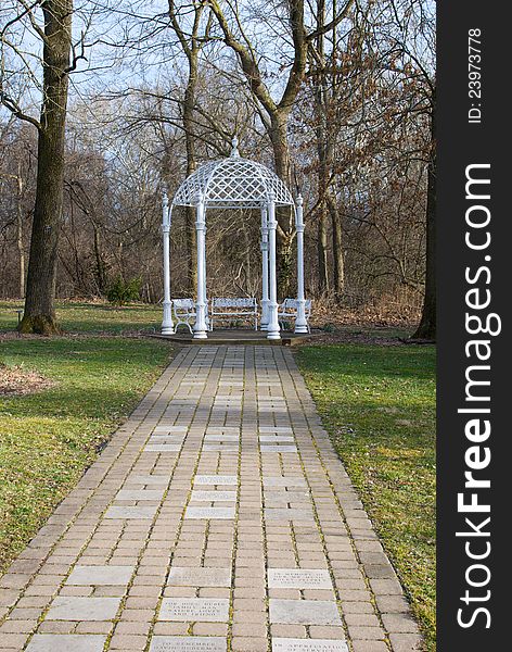 A white wrought iron gazebo at the Park of Roses in Columbus, Ohio, with a stone memorial path leading up to it. A white wrought iron gazebo at the Park of Roses in Columbus, Ohio, with a stone memorial path leading up to it.