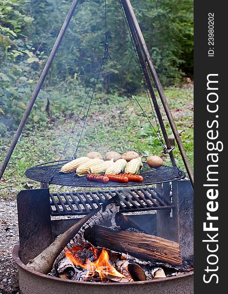 Hot dogs,corn and potatoes cooking on a grill at a Pennsylvania State Park. Hot dogs,corn and potatoes cooking on a grill at a Pennsylvania State Park.