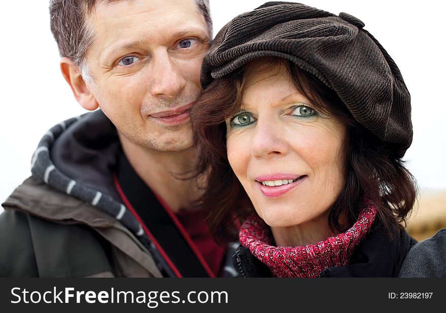 Mature couple portrait,outdoors with jacket and cap. Mature couple portrait,outdoors with jacket and cap