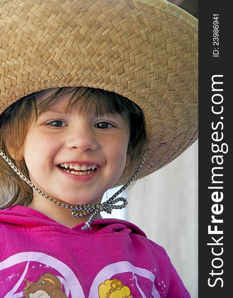 Small child, big hat, and big smile.