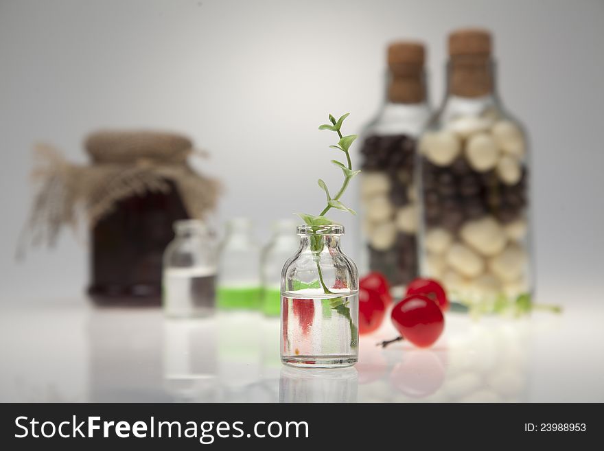 A glass, cherry and yellow flowers on a white back