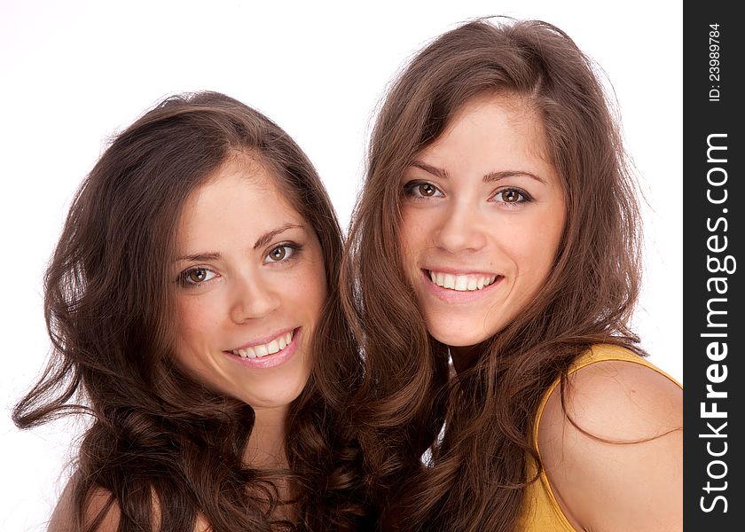 Two girls sisters - GEMINI on a white background. They are smiling.