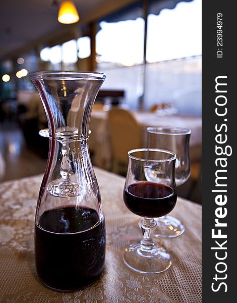 Bottle of red wine with glass on a restaurant table. Bottle of red wine with glass on a restaurant table