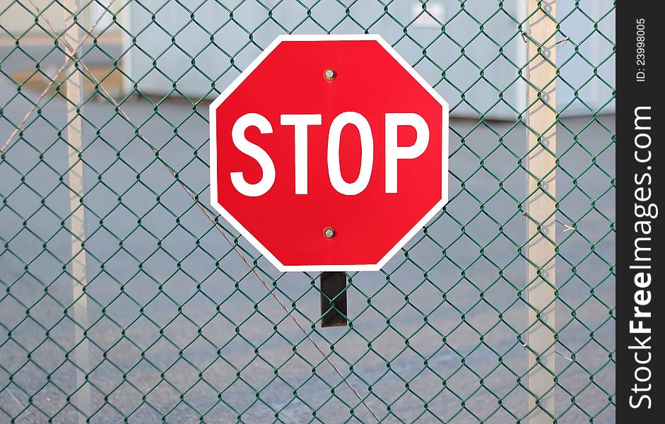 Stop sign on fence highlighting security