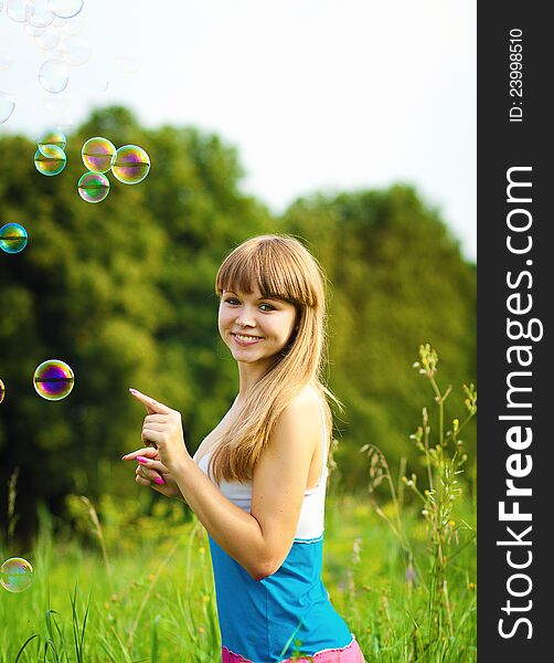 Happy fitness young woman playing with soap bubbles. Happy fitness young woman playing with soap bubbles