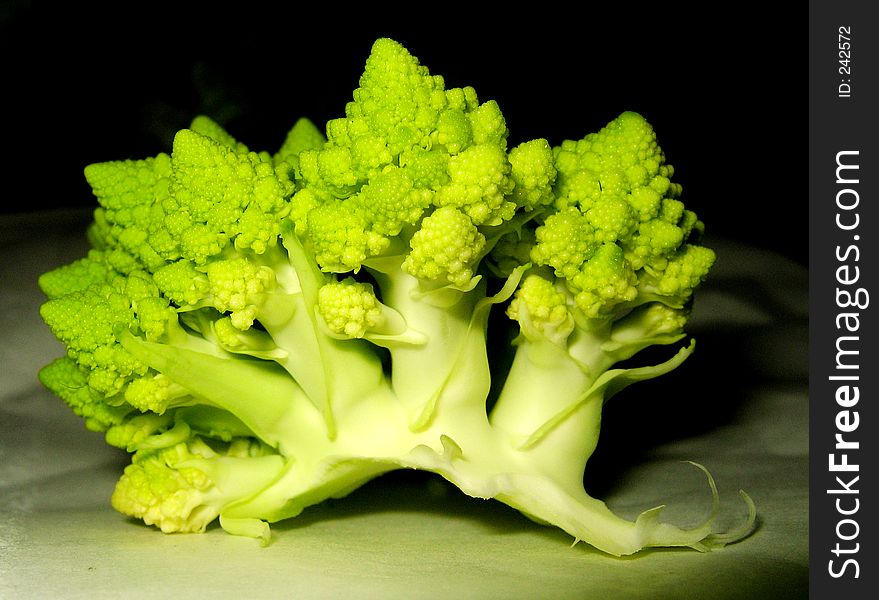 Part of fresh green cauliflower lying in the darkness