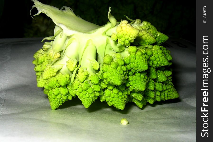 Part of fresh green cauliflower lying in the darkness