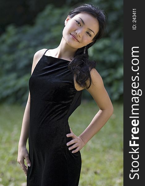 A beautiful chinese model in a black evening gown posing outside. A beautiful chinese model in a black evening gown posing outside