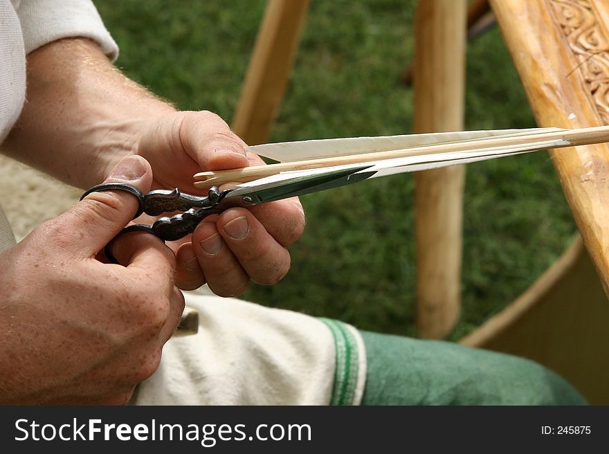 Picture of man making an arrow for shooting hes bow. Picture of man making an arrow for shooting hes bow.