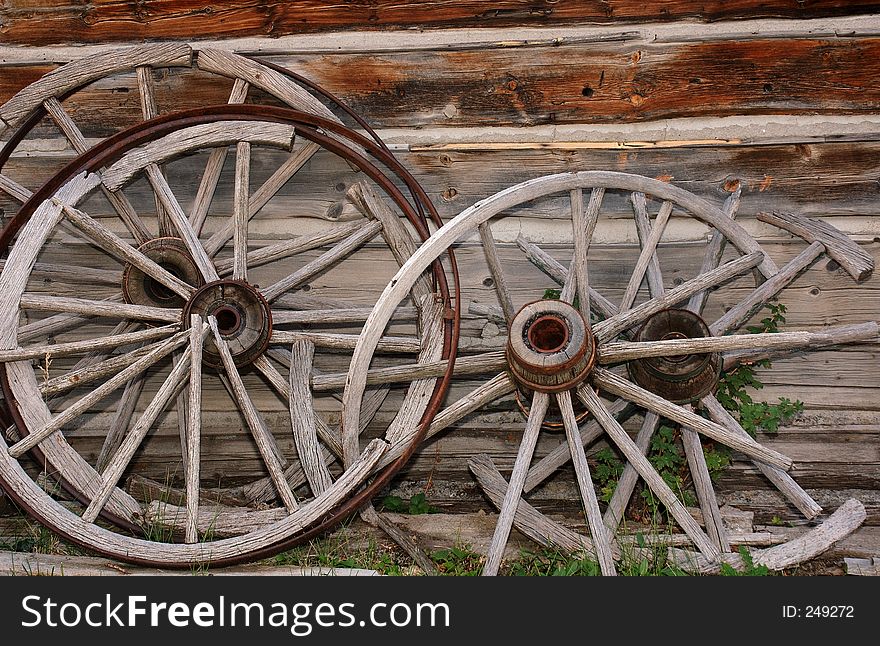 Broken wagon wheels leaning against a wall
