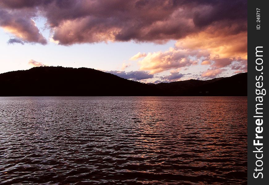 Sunset over the lake with mountains in the background