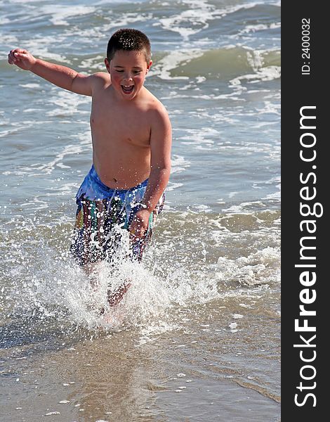 Little boy splashing in the surf