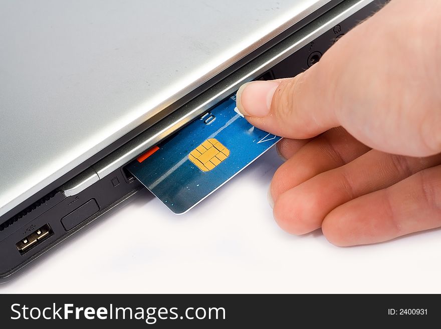 Credit card inserted in laptop with hand - Concept for Internet Banking & Shopping ISOLATED