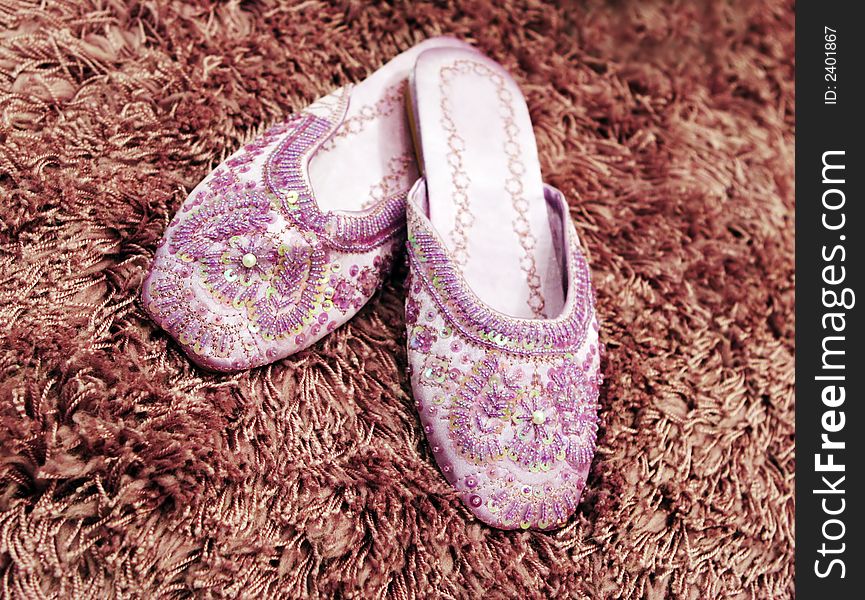 Pretty beaded slippers on thick wool carpet. Pretty beaded slippers on thick wool carpet