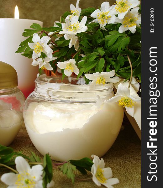 Container of cosmetic moisturizing cream with white flowers