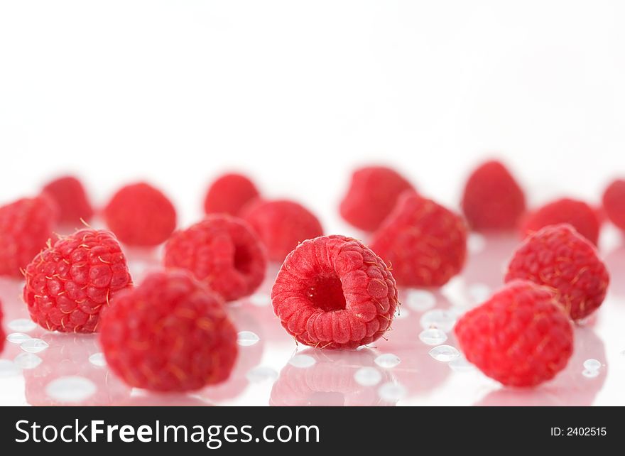 Raspberries on a white surface with water drops. Raspberries on a white surface with water drops.