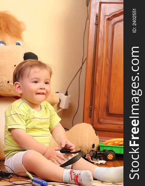 Little blond baby boy playing with toys at home