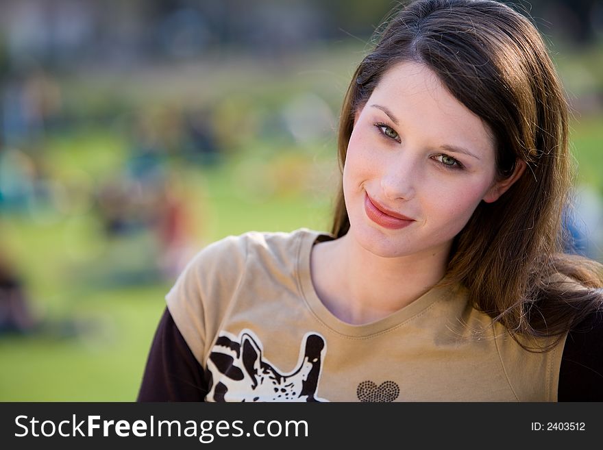 Beautiful young woman is standing in a park. Beautiful young woman is standing in a park