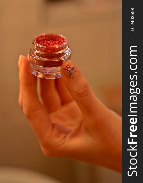 Makeup component eye shadow glass container in palm of a women hand with beatifully decorated nails. Makeup component eye shadow glass container in palm of a women hand with beatifully decorated nails