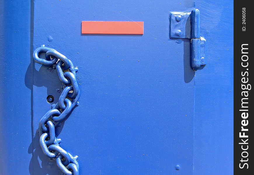 Blue chain at a metal door. Orange plate included.