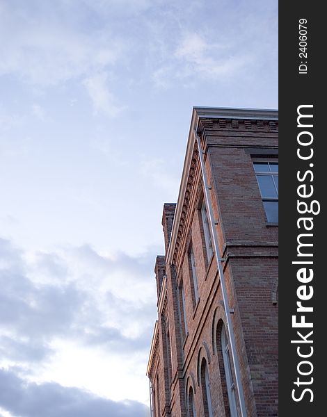 Old red brick building with big cloudy blue sky