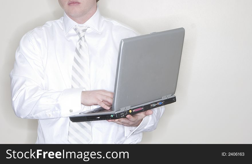 Businessman standing in his office holding his laptop in his hands. Businessman standing in his office holding his laptop in his hands