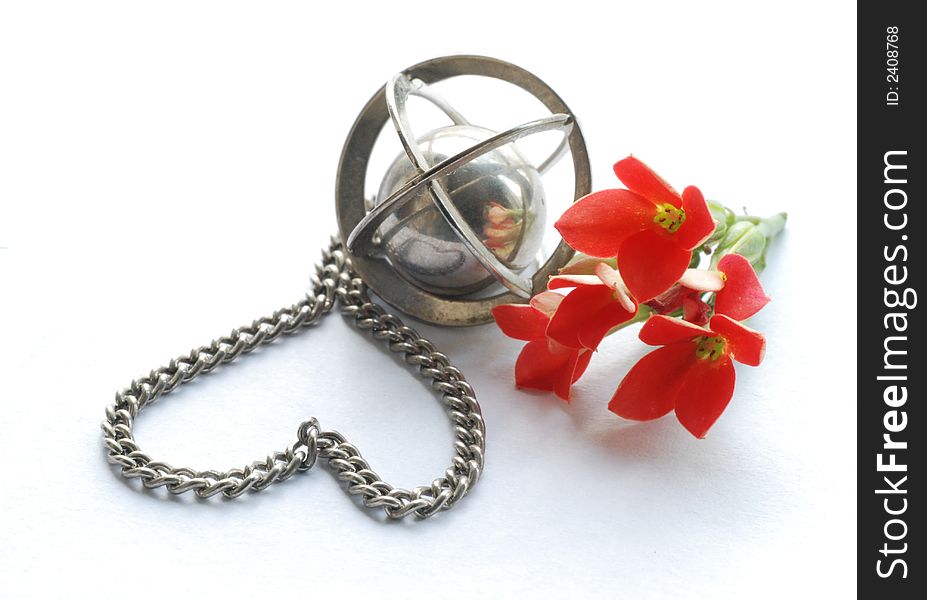 Little heart made of a chain, metal globe and red flowers. Little heart made of a chain, metal globe and red flowers