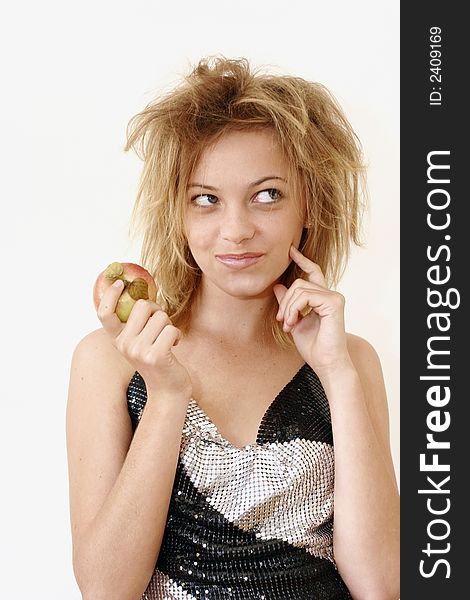 Teenage girl with apple in hand, finger on cheek, looking upward