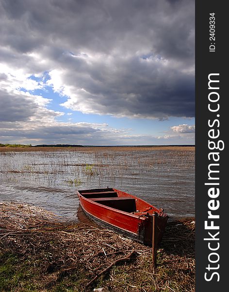 A boat by the lake on a stormy day. A boat by the lake on a stormy day