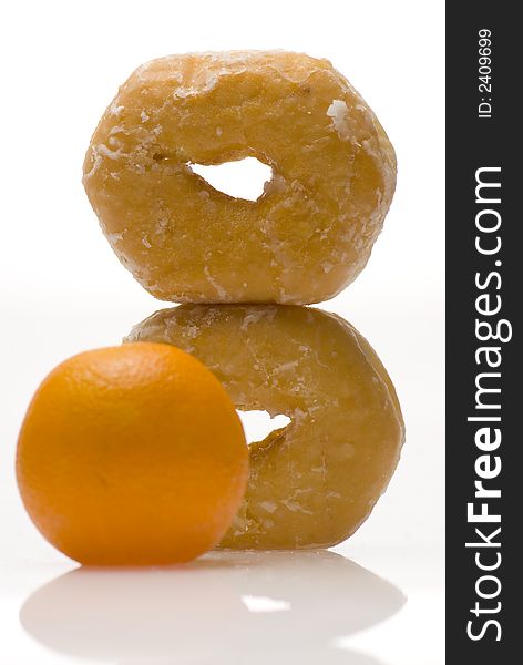 Two donuts balancing and stacked vertically with orange. Two donuts balancing and stacked vertically with orange