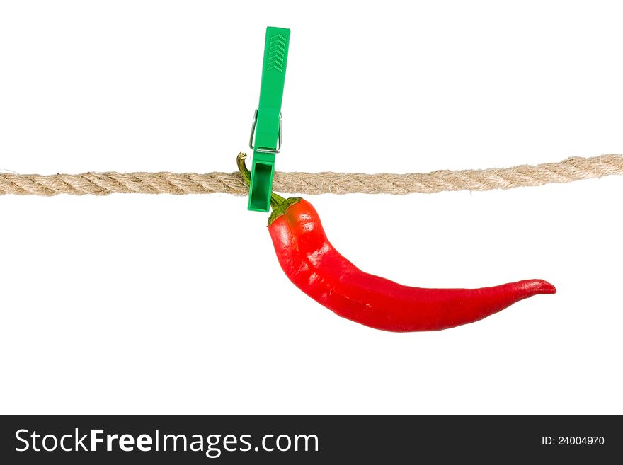 Red pepper chile on clothes-peg rope isolated on white background.