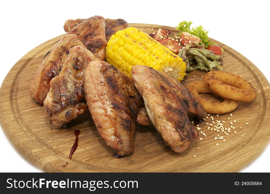 Chicken wings with sweet corn on a wooden plate