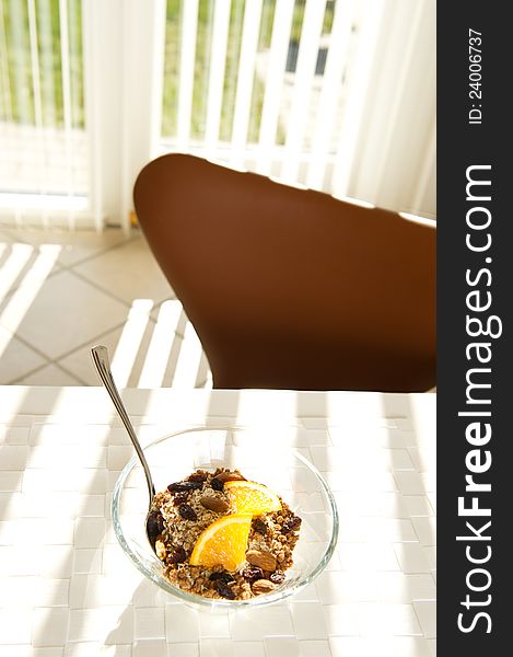 Healthy muesli with orange in the morning sun