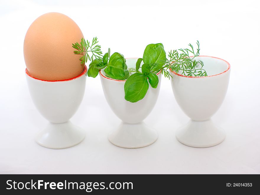 Egg and three eggcups , decorated with greenery. Egg and three eggcups , decorated with greenery