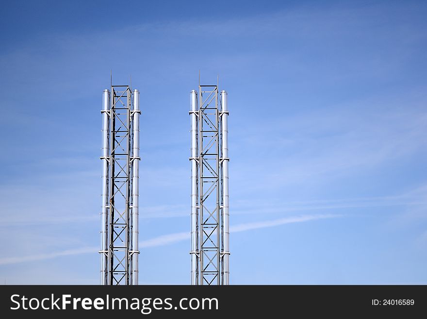 Steel factory chimneys with blue sky. With copyspace