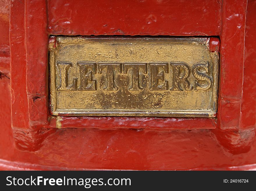 Close view of a brass flap with word LETTERS, part of a red Post Office pillar. Close view of a brass flap with word LETTERS, part of a red Post Office pillar