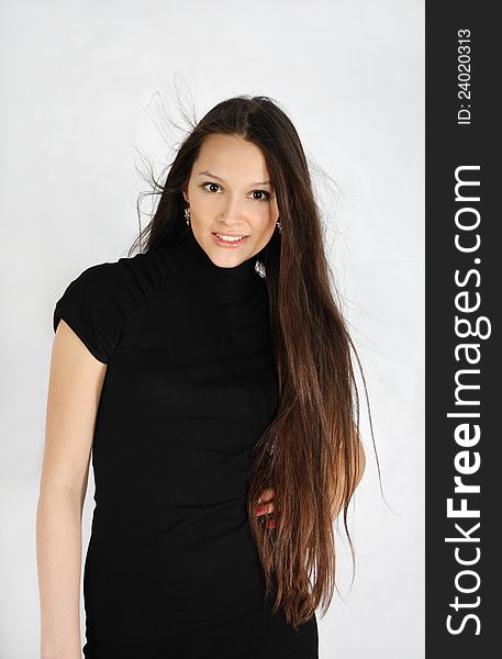 Brunette Girl Wearing Black Dress Looks At Camera