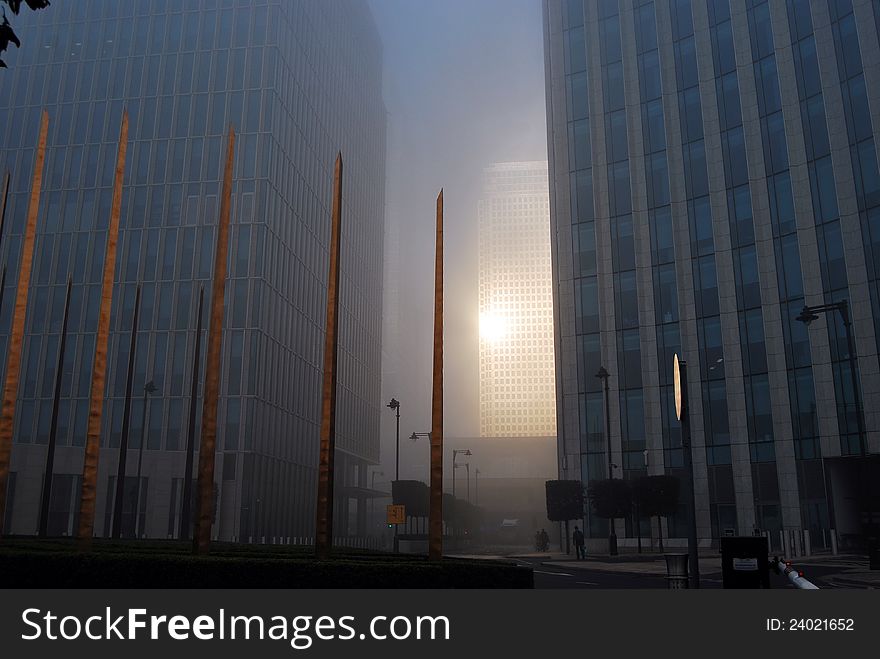 Early morning sunrise reflected through the fog from the tower of One Canada Square, Canary Wharf, London Docklands, seen from Cartier Circus. Early morning sunrise reflected through the fog from the tower of One Canada Square, Canary Wharf, London Docklands, seen from Cartier Circus.