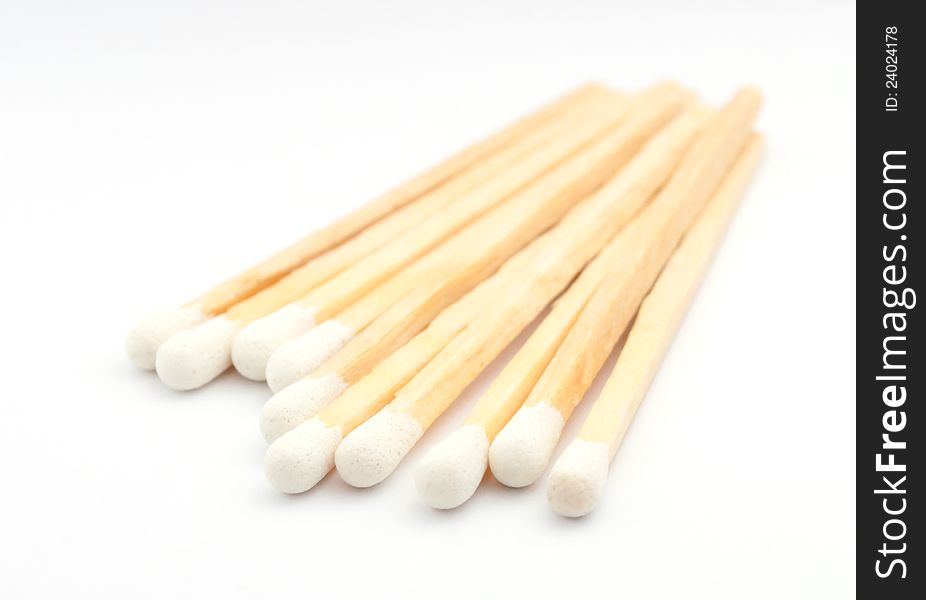 Stack of matches with white heads on white background. Stack of matches with white heads on white background