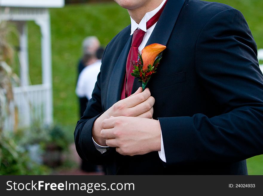 A groom at a wedding, detail of his flower corsage. A groom at a wedding, detail of his flower corsage