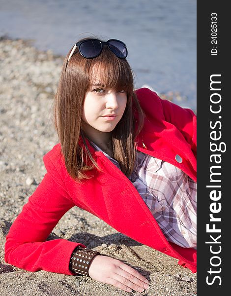 A girl in a bright red coat and sunglasses. A girl in a bright red coat and sunglasses