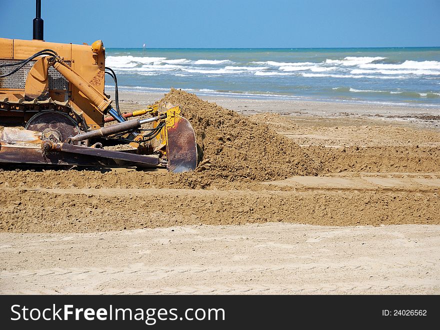 Bulldozer in the sand near the sea