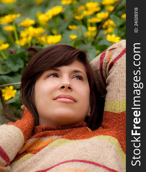 A portrait of a gorgeous young woman, reclining amid a field of bright yellow flowers, looking peaceful and content. A portrait of a gorgeous young woman, reclining amid a field of bright yellow flowers, looking peaceful and content