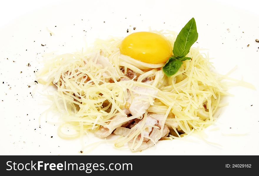 Spaghetti with egg and greens on a white plate