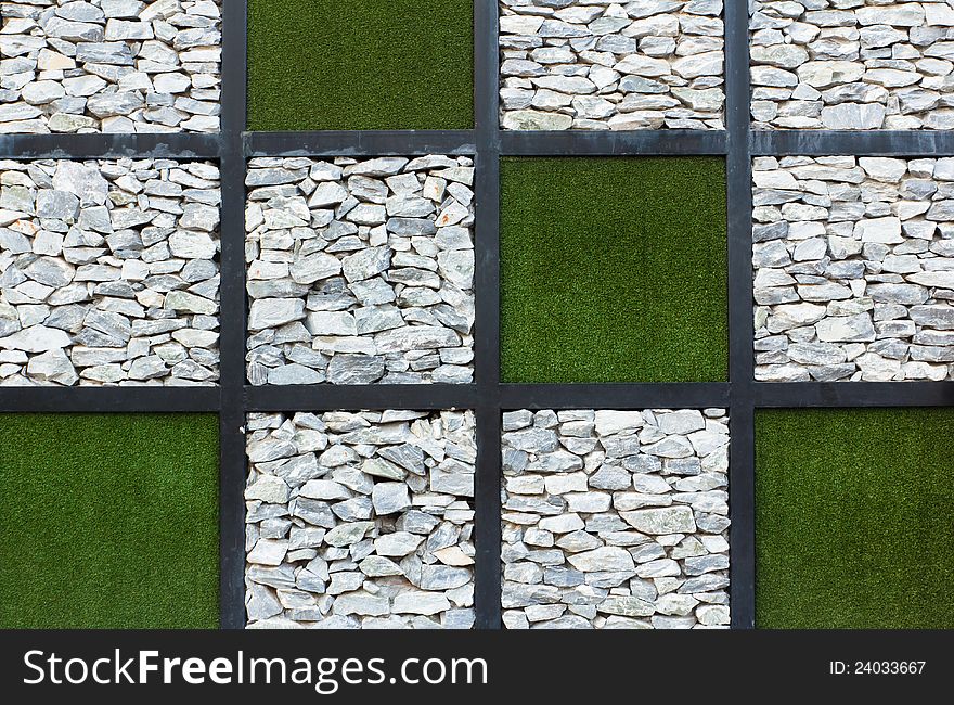 The stones and grass wall background. The stones and grass wall background