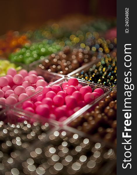 Multi-colored beads in a box on a shelf in the market. Multi-colored beads in a box on a shelf in the market