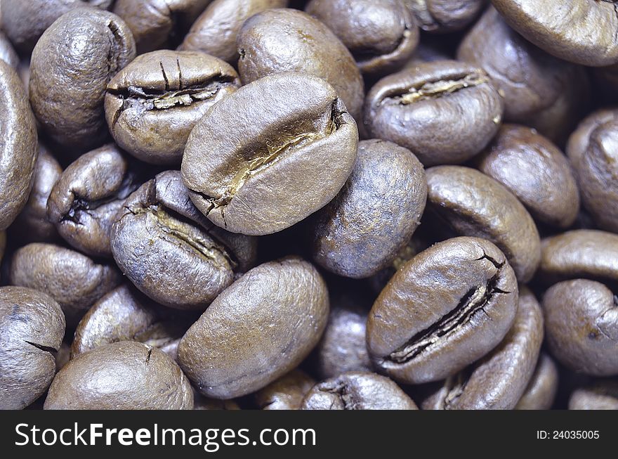 Closeup shot of roasted coffee beans; focus on central bean. Closeup shot of roasted coffee beans; focus on central bean